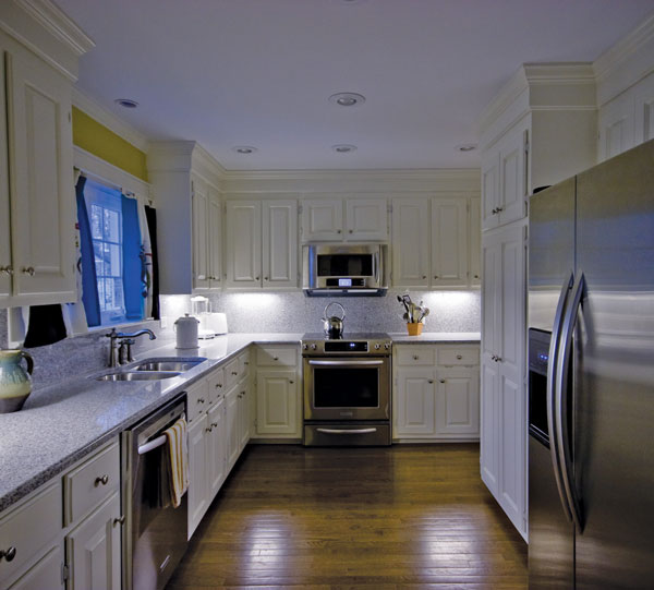 
AFTER. With its original wood cabinets, the kitchen was updated with energy star appliances and a built-in recycling center.
